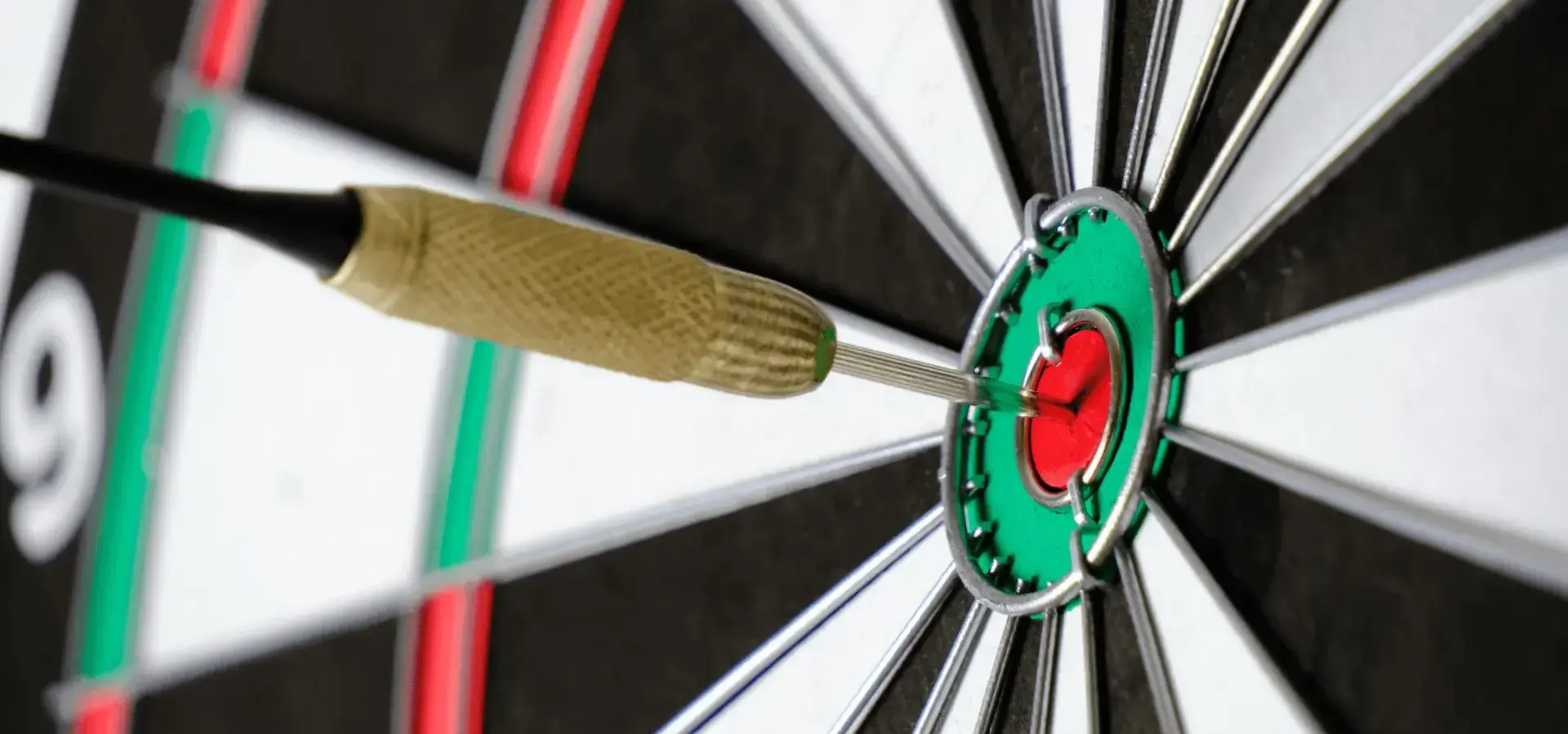 Close-up dartboard with a dart dead-centre of the bullseye.